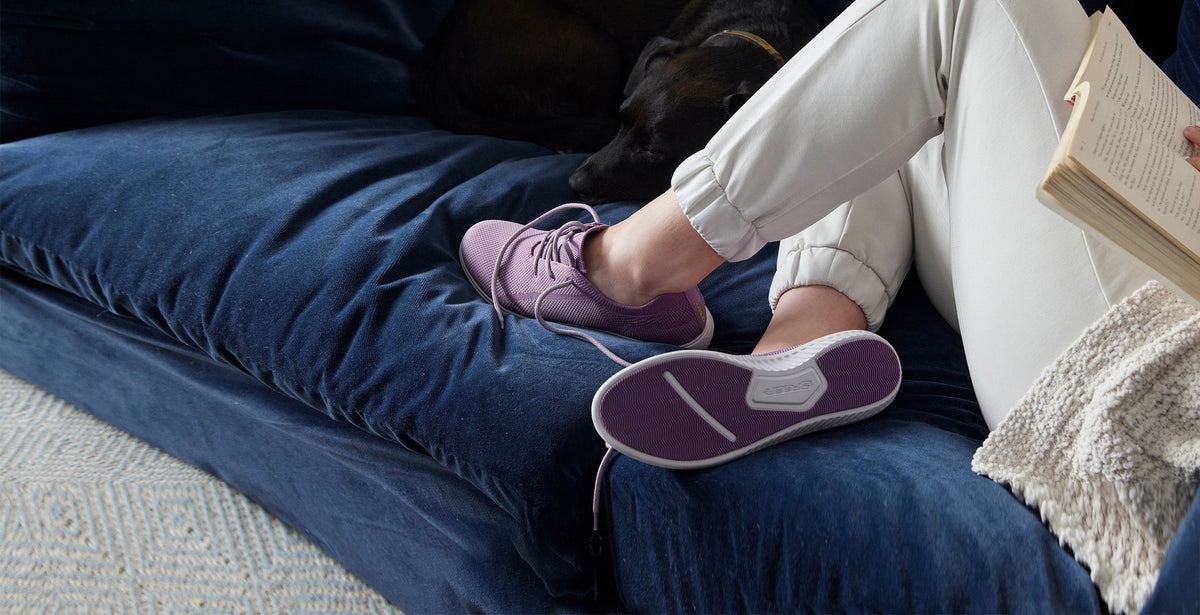 Person sitting on couch wearing greenReActives shoes